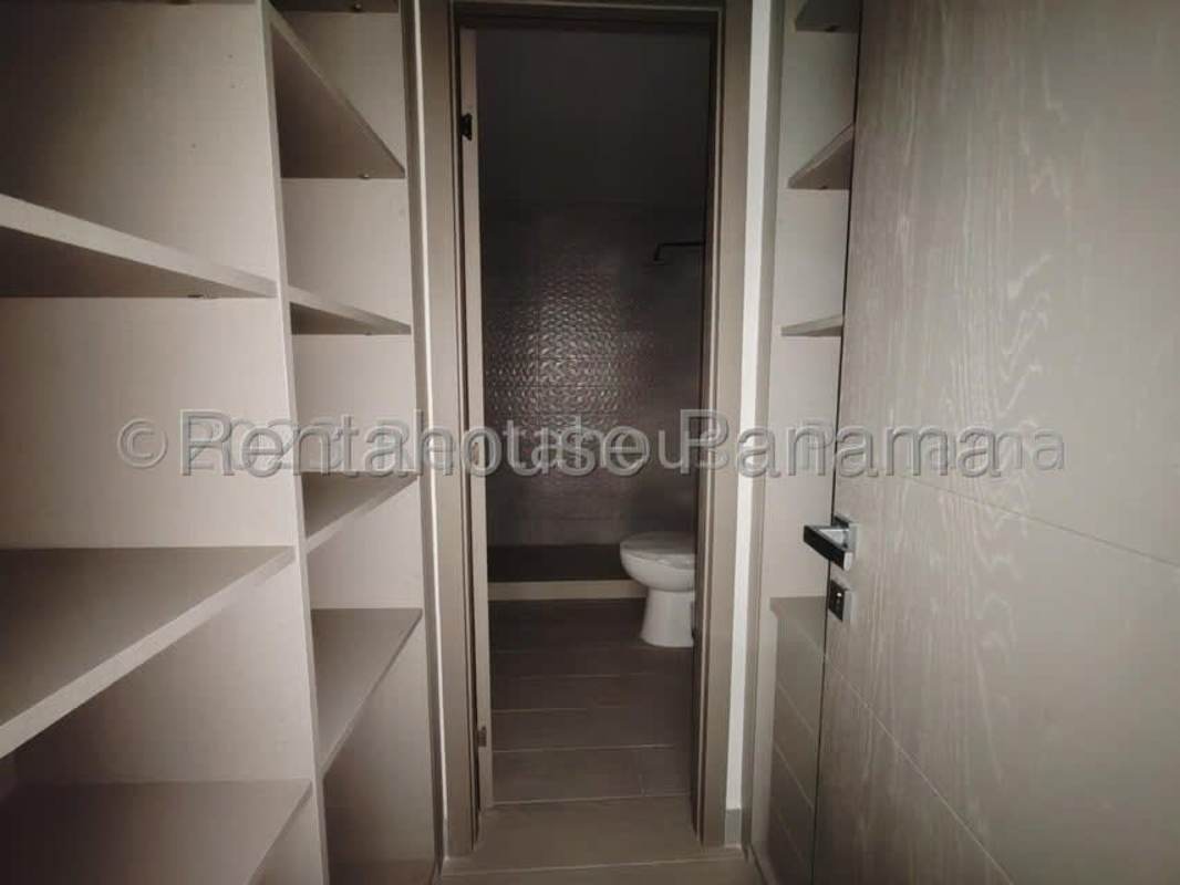 Closet with built-ins leading to bathroom, laminate floors in PH Downtown Obarrio Panama