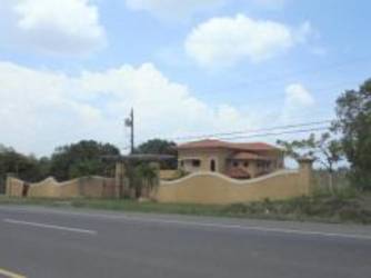 Modern kitchen with central island and large windows in two story house for sale Rio Hato Panama