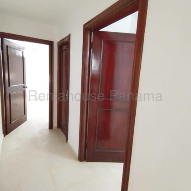 Bright hallway with multiple wood doors tiled floors Costa Bella house Panama