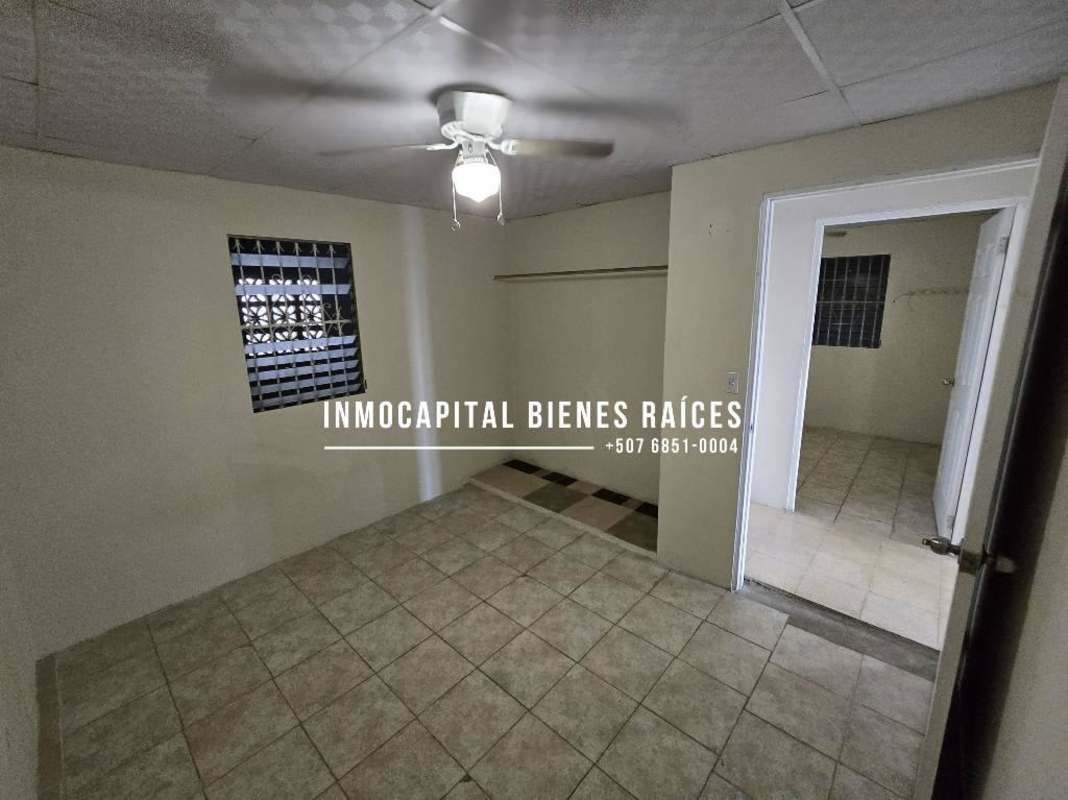 Bedroom with beige walls, tile floors, barred window in Don Bosco Panama