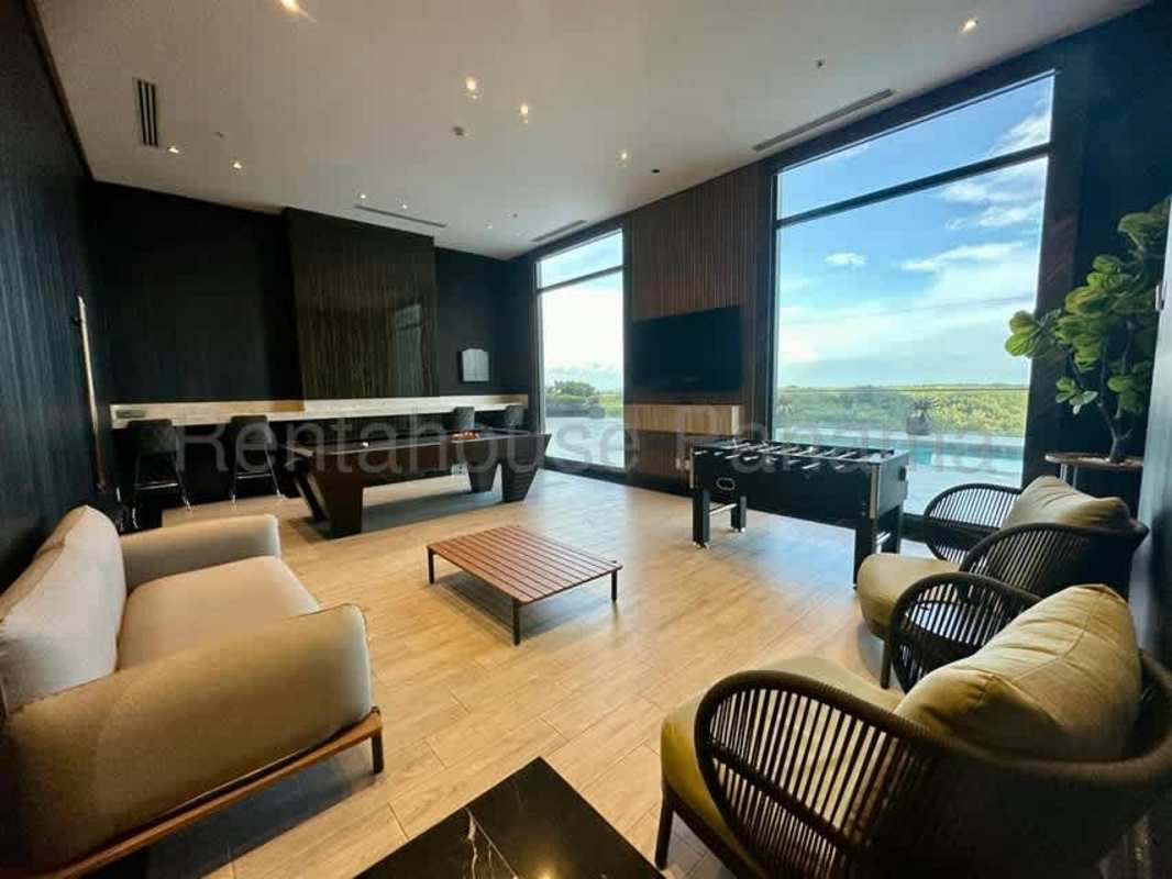 Bright living room with floor-to-ceiling windows, marble floors, city and golf views at Empire Residences Panama