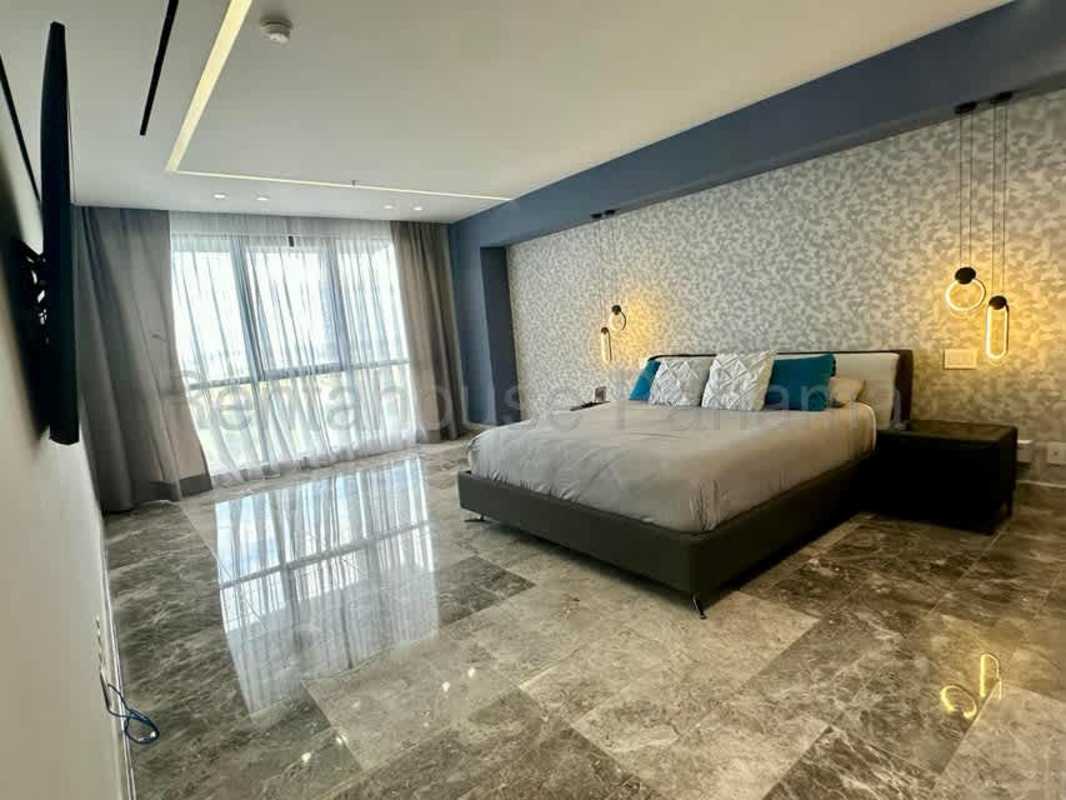 Spacious master bedroom with large windows, ensuite bath, and walk-in closet in Empire Residences Santa Maria