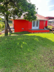 Small red cottage with patio, white doors, green yard and tree Cerro Cama Panama