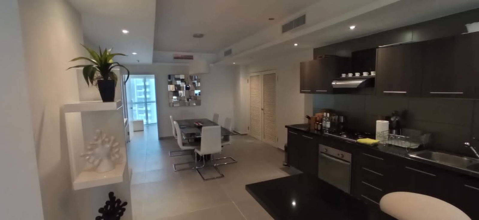 Open kitchen with sleek cabinetry and porcelain floors in PH BICSA apartment on Avenida Balboa