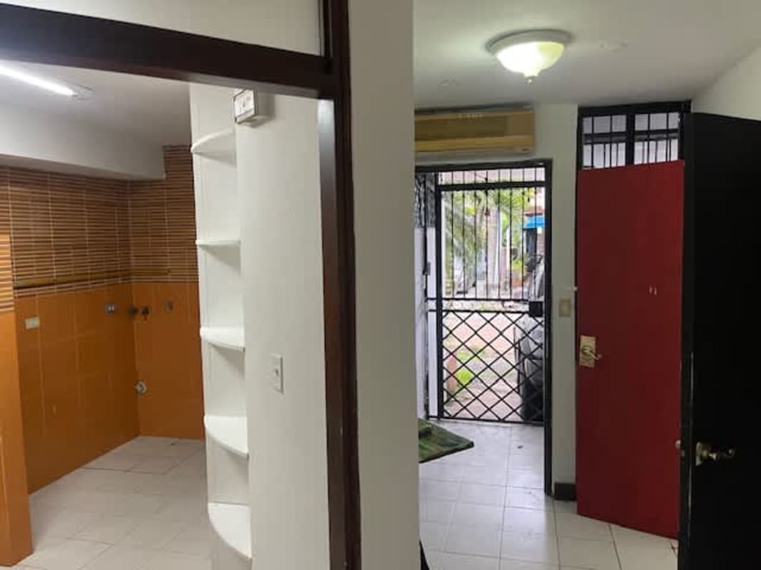 Entryway with open kitchen, orange tiles, wood front door, security gate Obarrio townhouse Panama City