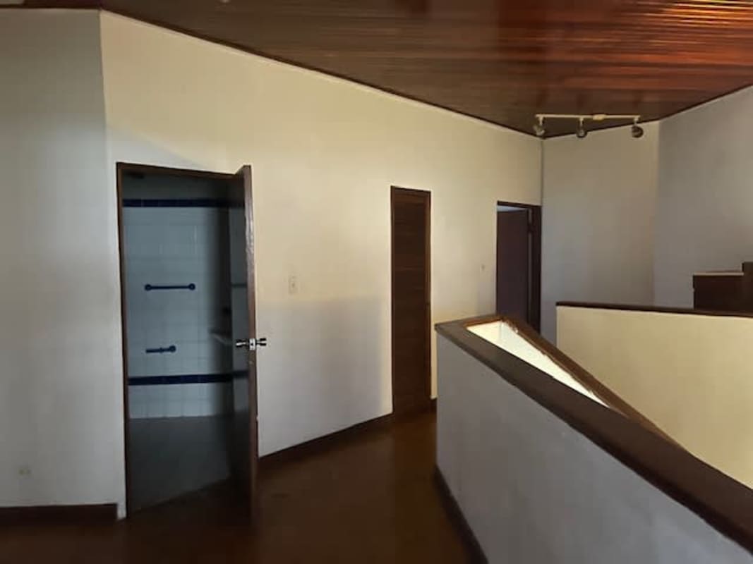 Floating wooden staircase in townhouse in Obarrio Panama City with panel ceiling and white walls