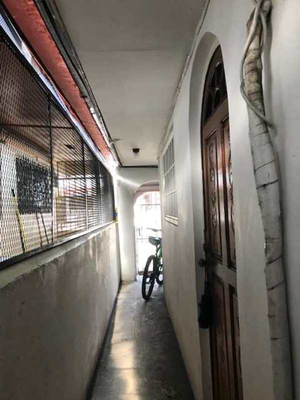 Apartment corridor with arched window and metal grille at Villa Cáceres Panama City