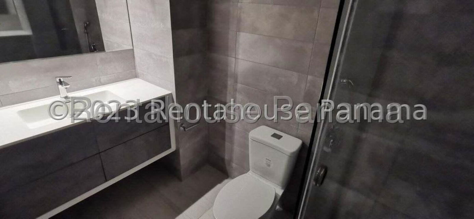 Contemporary bathroom with wall-mounted sink mirror and glass shower door at PH Urbana Panama