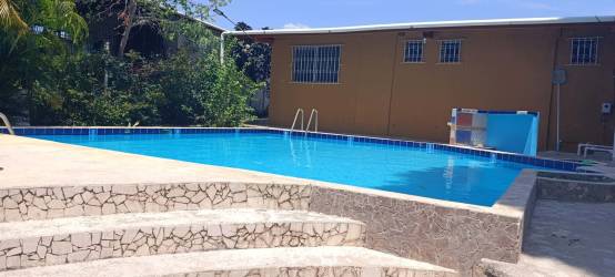 Outdoor swimming pool with privacy fence and tiled deck near Playa San Carlos ideal for rentals