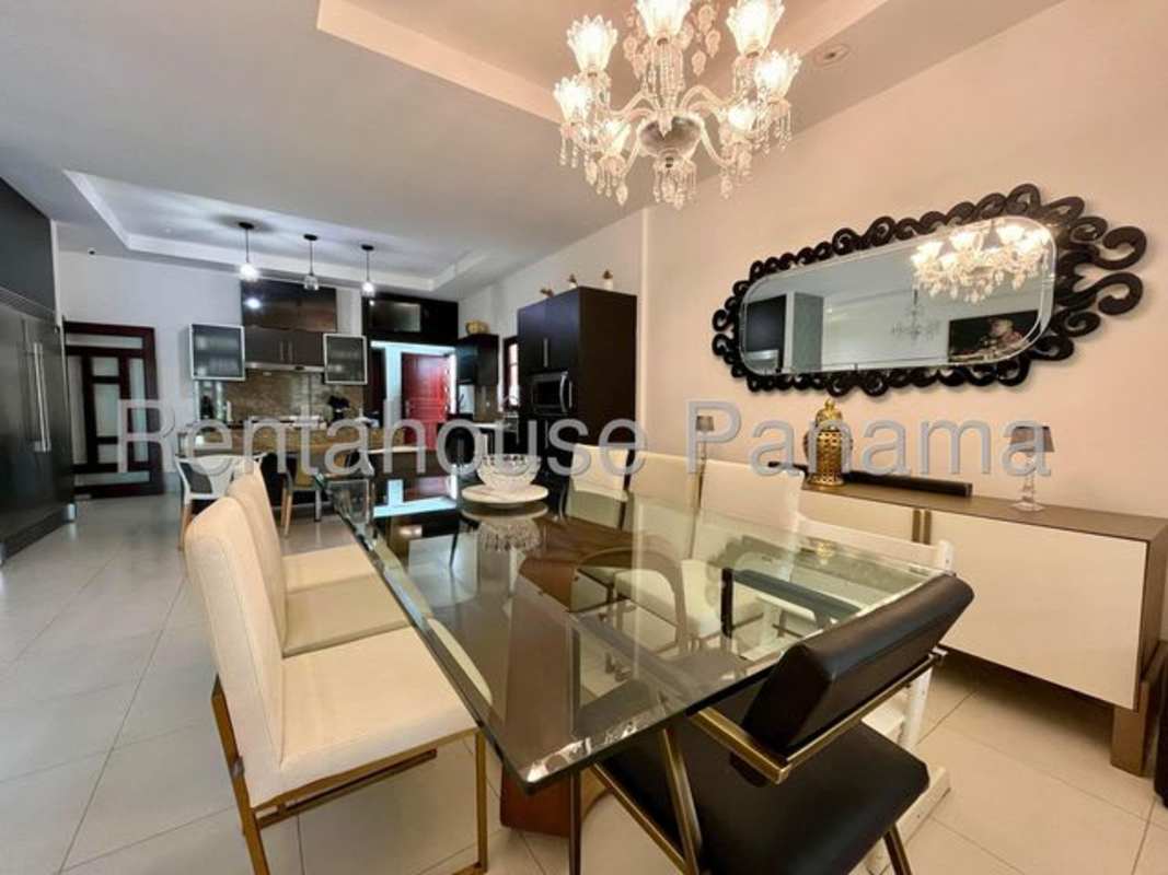 Contemporary dining room with glass table chandelier and large mirror in house Sunset Coast Costa Sur Panama