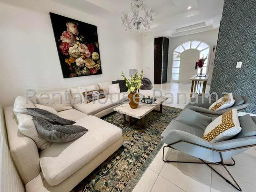 Spacious master bedroom with balcony access, chandelier and modern decor in Sunset Coast Costa Sur Panama City