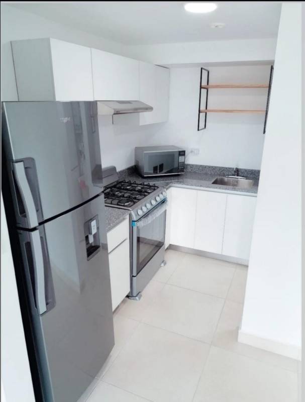Compact kitchen with granite countertops, stove, microwave and refrigerator in apartment for rent Panama Viejo