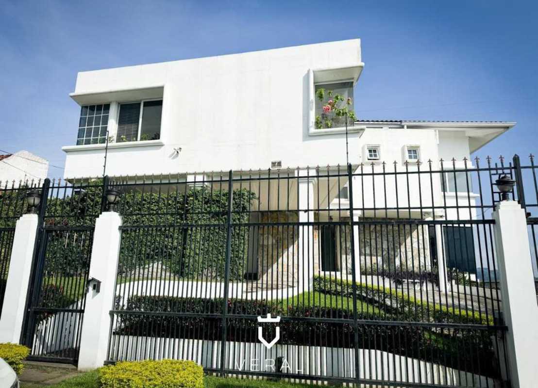 White contemporary two story villa with black railing and landscaped garden in Betania El Avance