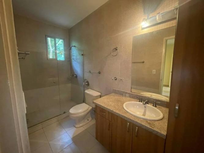 Covered terrace with tiled floor overlooking the fenced garden in Embassy Gardens Clayton Panama