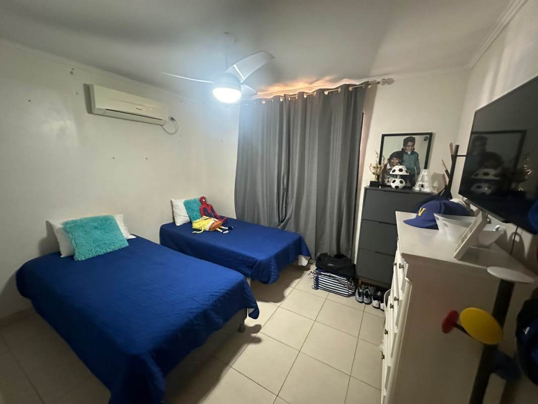 Bedroom with twin beds, blue bedding, and AC unit in Villa Zaita Panama City