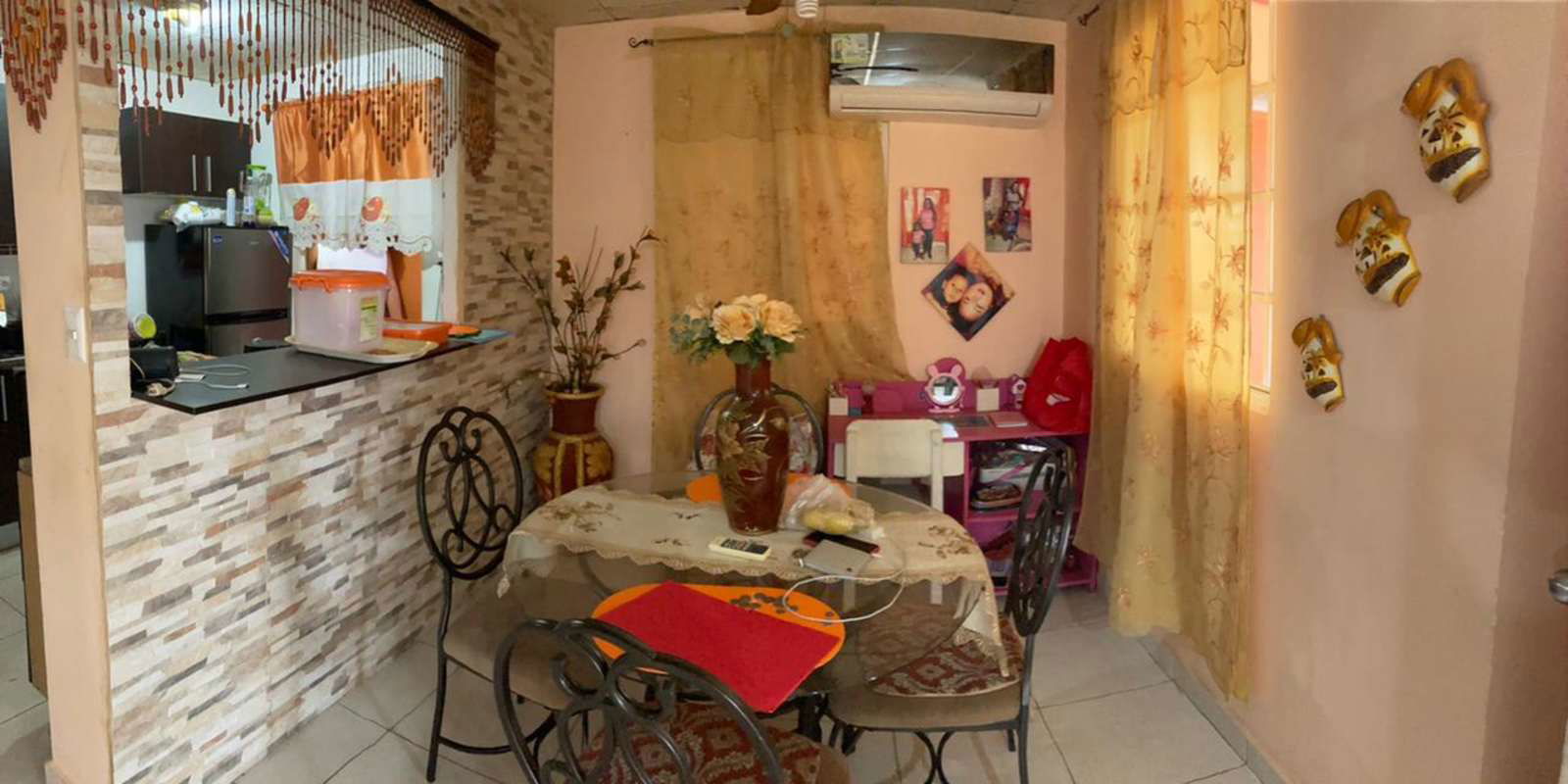 Open kitchen with breakfast bar and dining table in remodeled Pacora house Panama