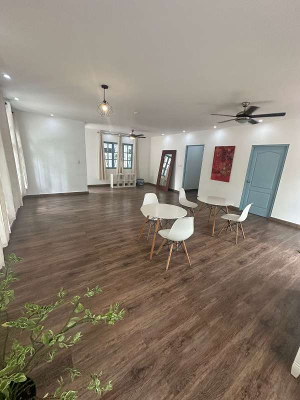 Spacious living area with wood floors, large windows, ceiling fans in Panama house Obarrio