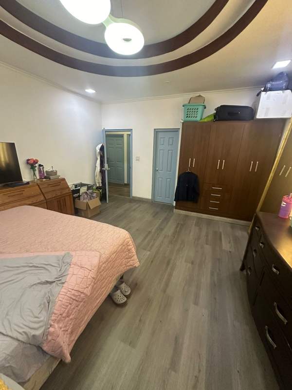 Bedroom with wood floor, built-in closet, AC unit and natural light in Panama home Obarrio