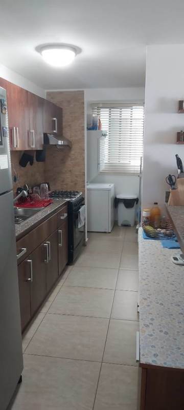 Galley kitchen wood cabinetry gas stove PH Park City Condominiums Condado del Rey Panama