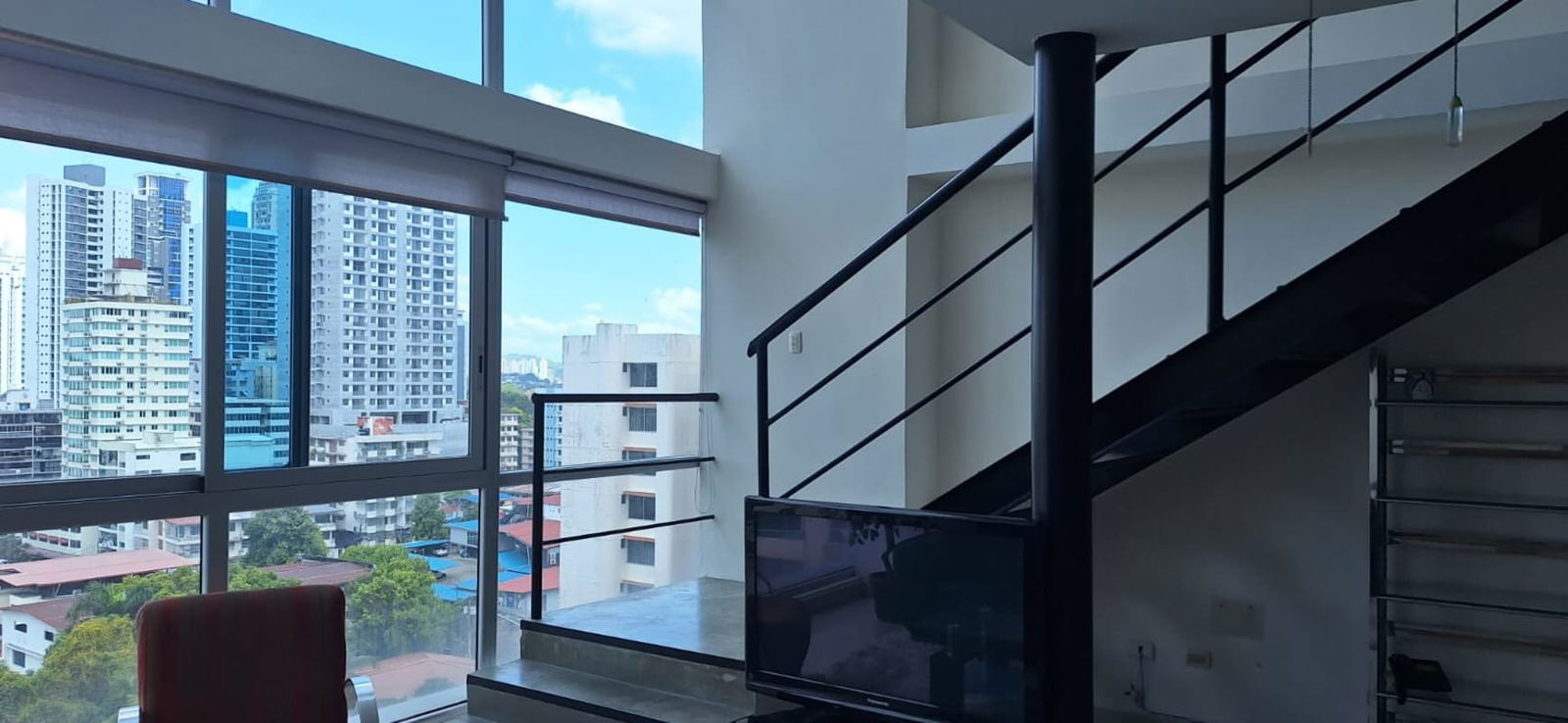 Modern loft living room with floor-to-ceiling windows and urban views PH Vitroloft El Cangrejo Panama