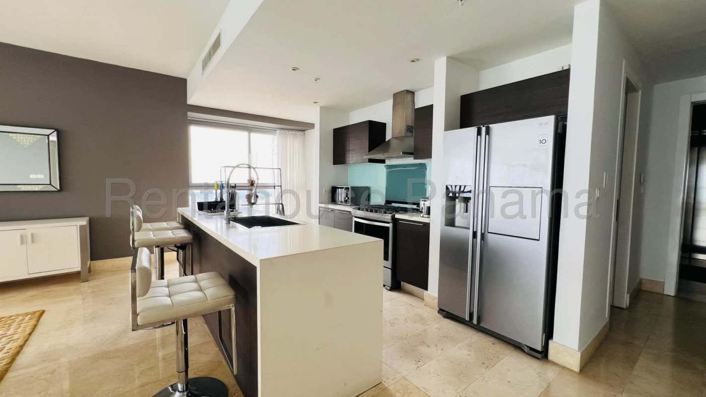 Modern penthouse kitchen with island, stainless appliances, marble floors and Pacific Ocean views at PH BICSA Tower Panama City