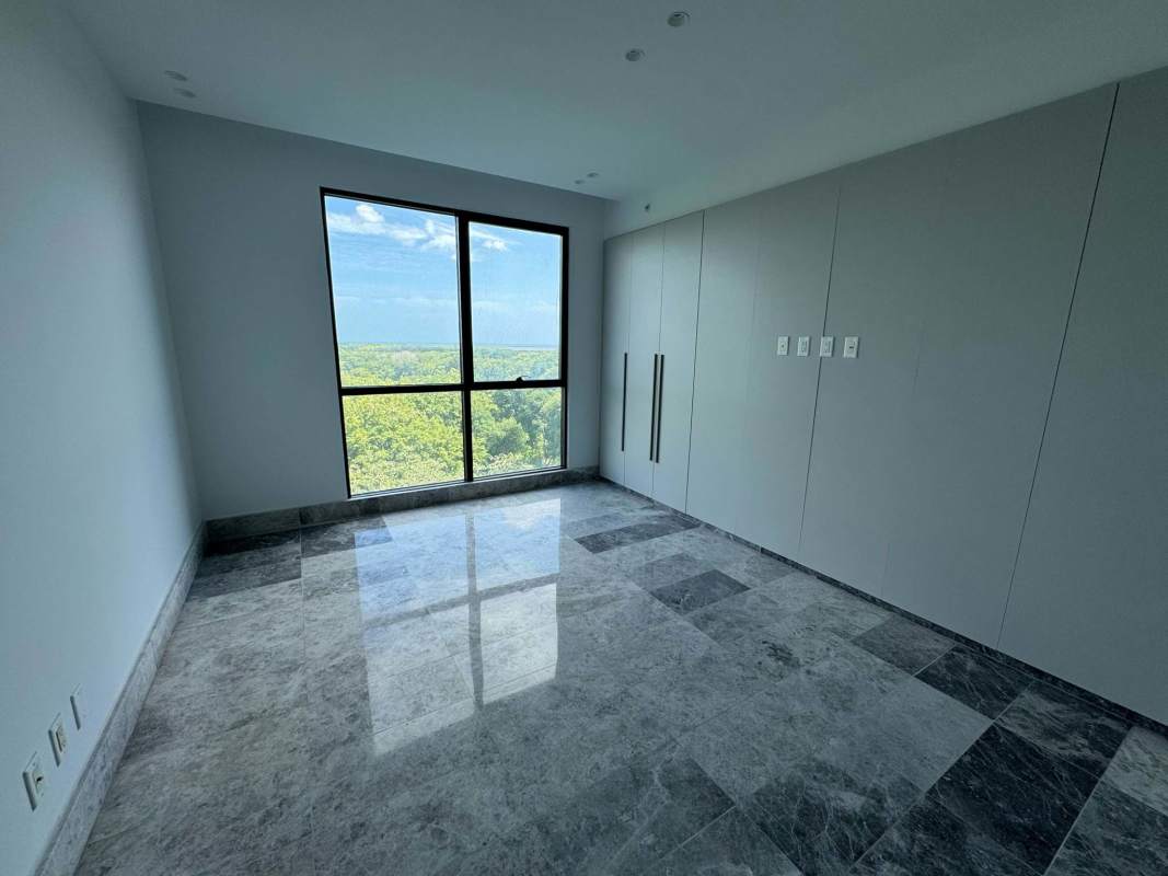 Spacious bedroom with large window, built-in wardrobe marble floor at Empire Residences Santa María Panama