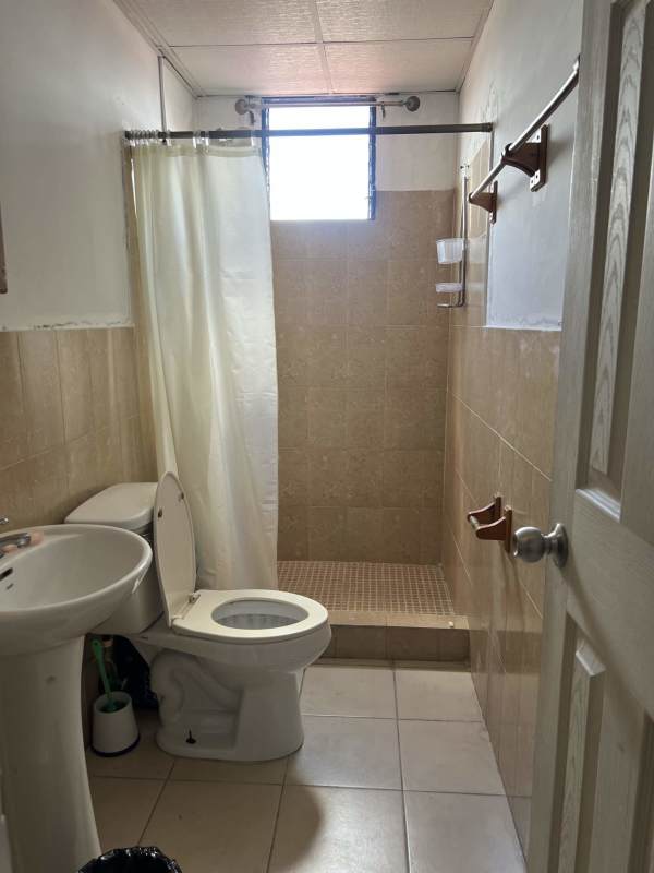 Compact bathroom with tiled walls, pedestal sink, shower at PH Saramel Panama City