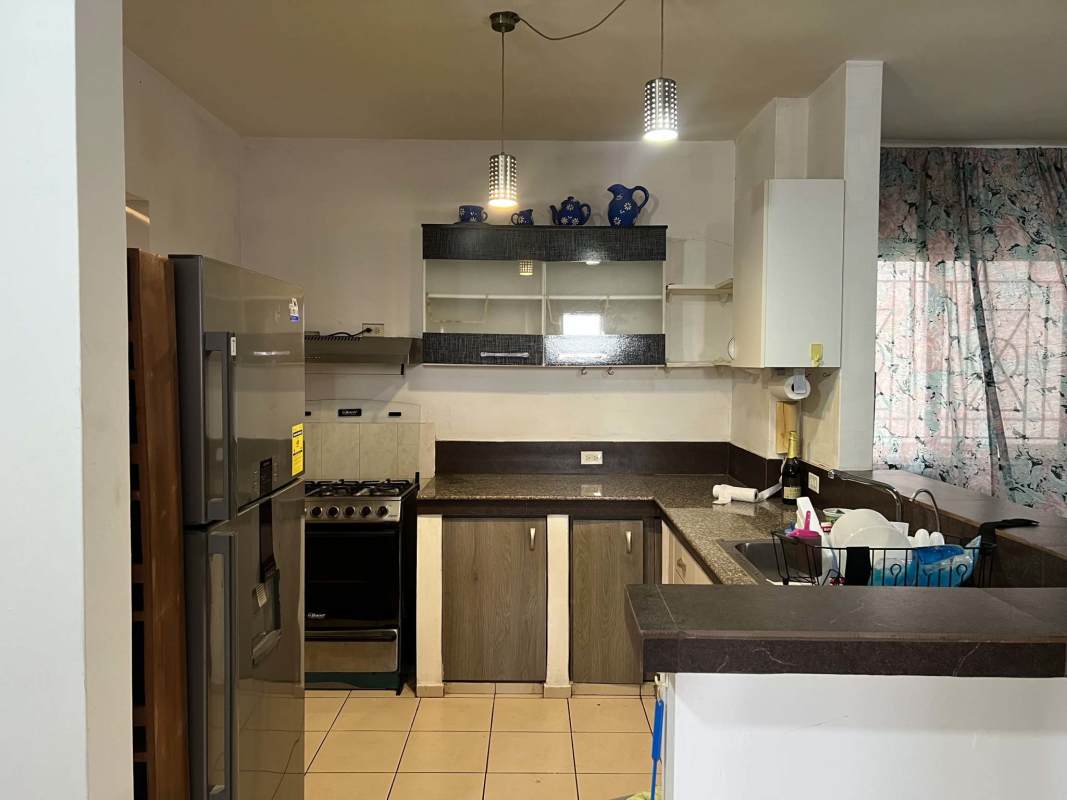 Kitchen with refrigerator, stove, laminate counters and pendant lights in PH Saramel Panama City
