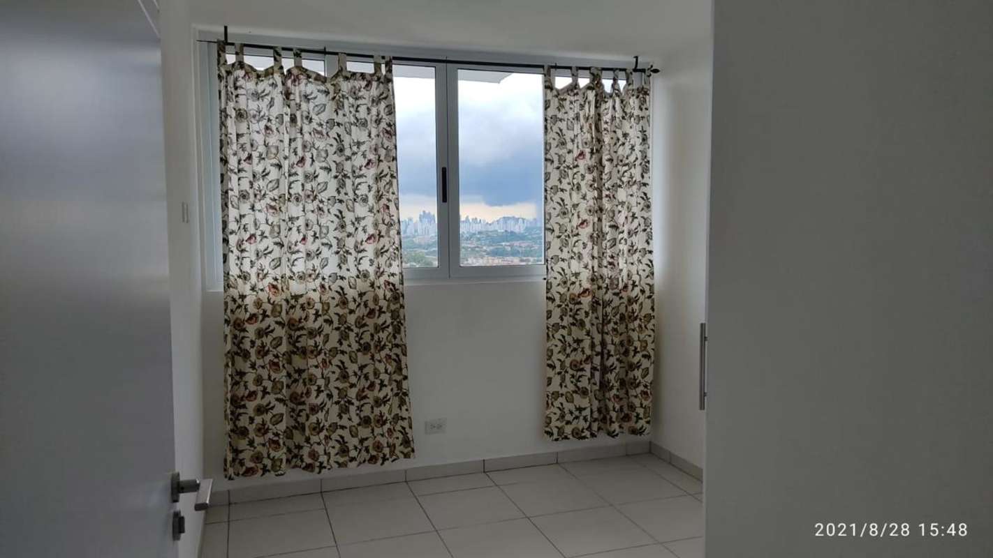 Bedroom with floral curtains, large window and closet space in Panama City apartment