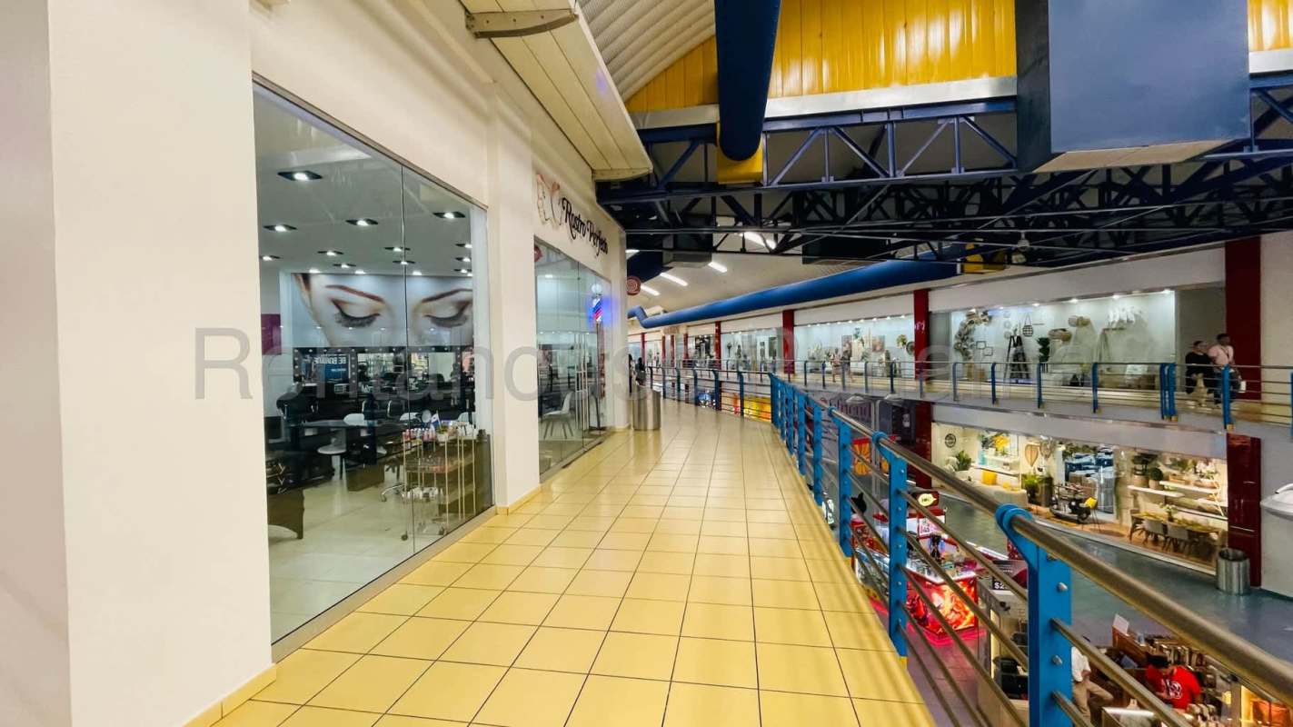 Shopping center corridor with multi-level stores, glass storefronts Albrook Mall Panama
