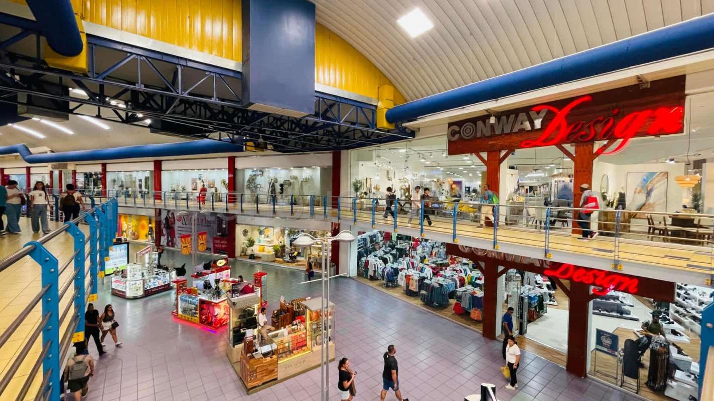 Wide corridor in Albrook Mall with stores and seating for customers Panama City
