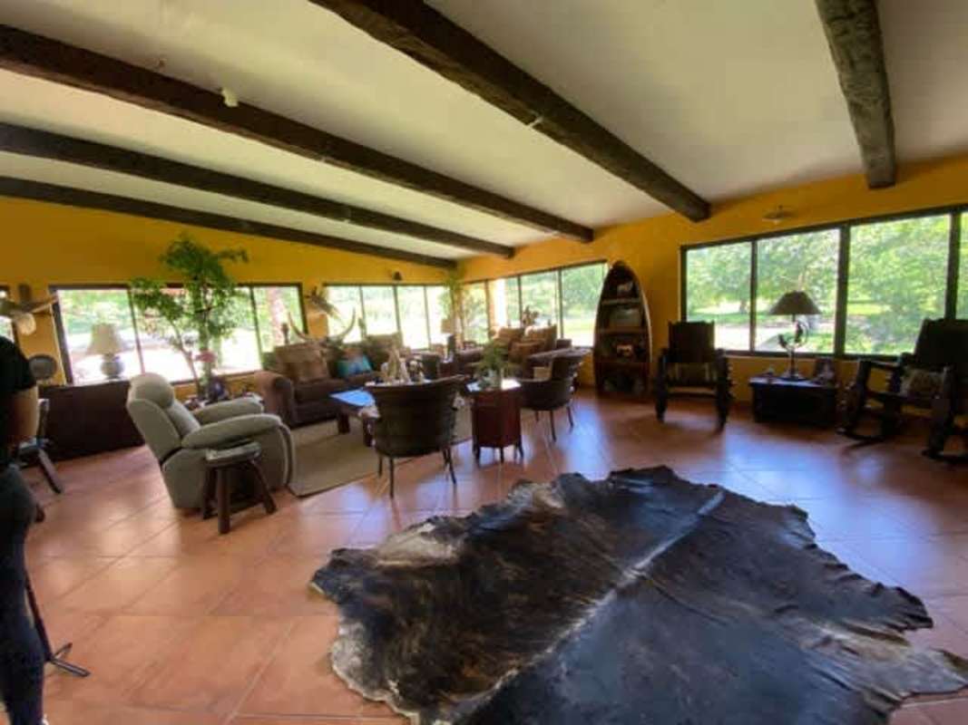 Single-story yellow hacienda style house with lawn at Panama ranch estate