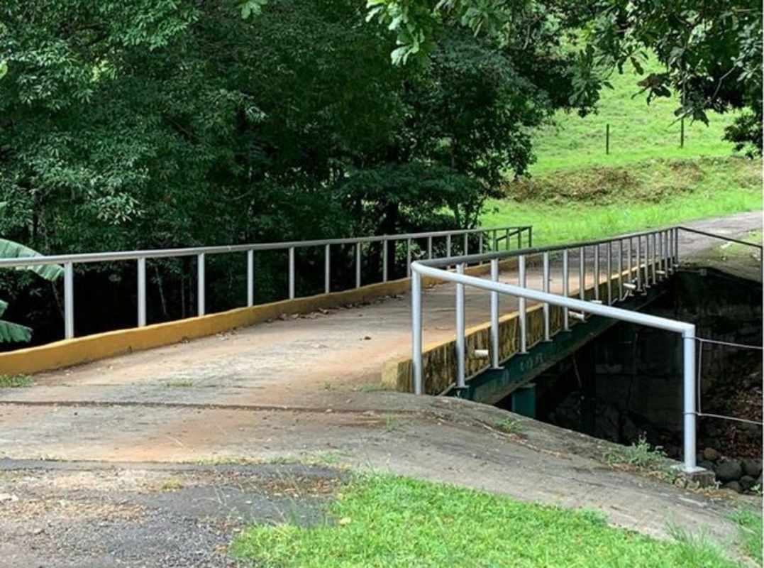 Rustic living room with beamed ceiling, tile floors and large windows on Panama ranch