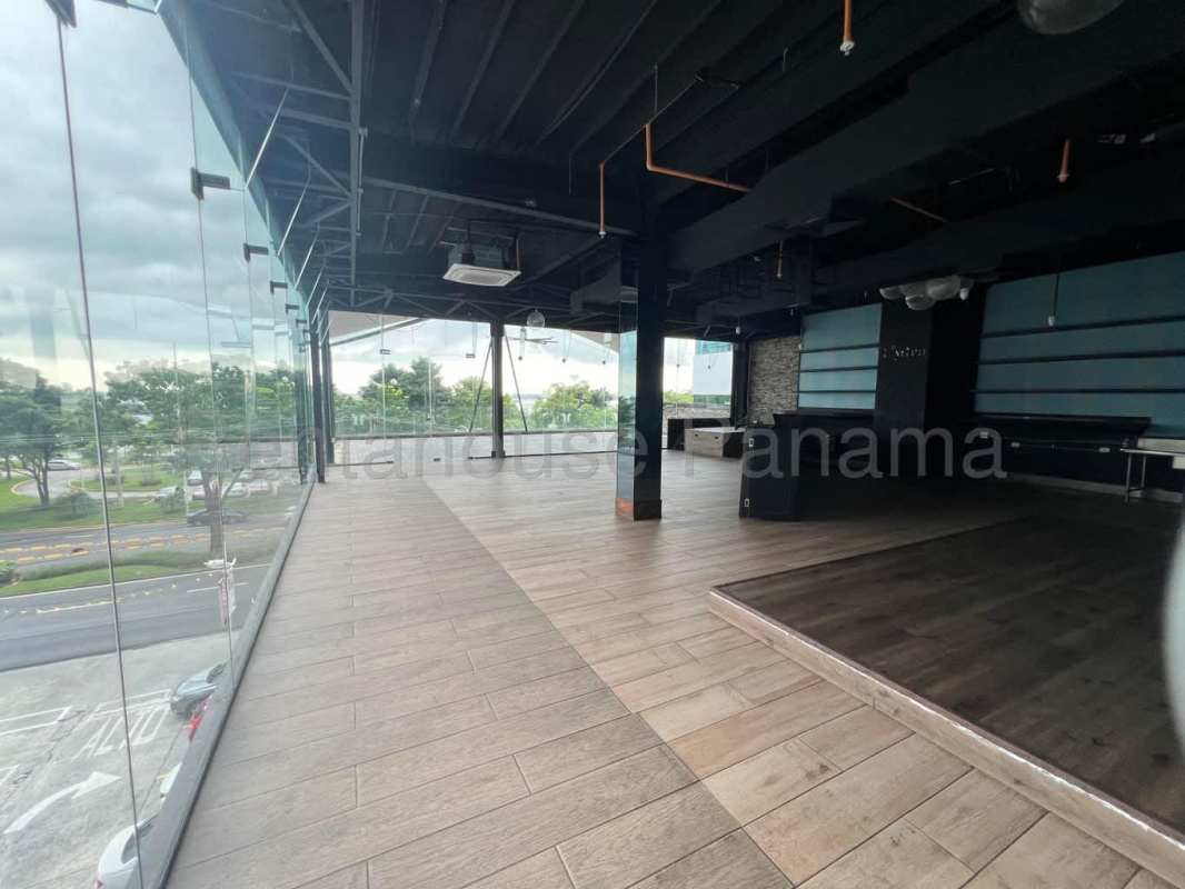 Commercial open area with glass walls overlooking city and coastline, perfect for custom business setup