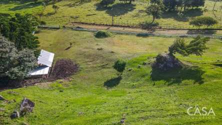 Open rural pasture with rolling hills, trees, mountain backdrop near Volcán Panama real estate