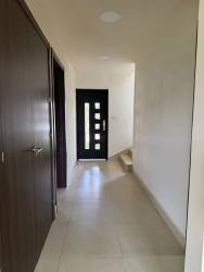 Entrance hall with modern black front door and tile floor Los Molinos house Boquete