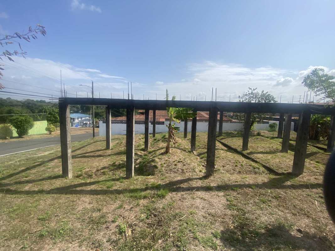 Concrete posts and beams over grassy lot suburban Panama Las Cumbres
