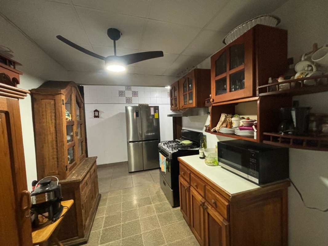 Kitchen with dark wood cabinets, tiled backsplash and ceiling fan