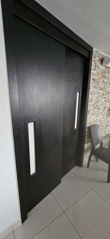 Entry with sliding black door and stone accent wall inside Jardines de Costa del Este Costa del Este Panama City