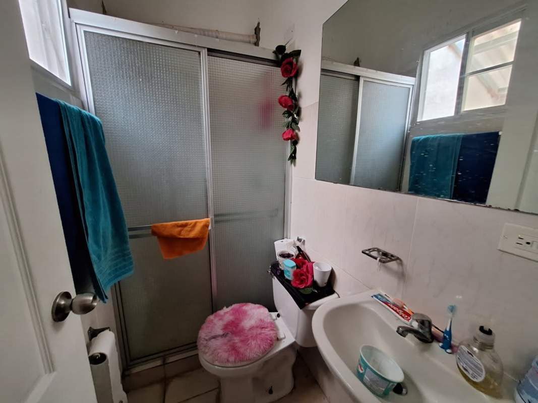 Fully tiled bathroom with shower and large mirror in Villas del Naranjal Pedregal Panama