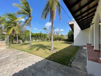Outdoor covered terrace with hammock and garden view in Coronado Beach house