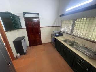 Dining area with wooden ceiling beams, round glass table and natural lighting at Coronado rental