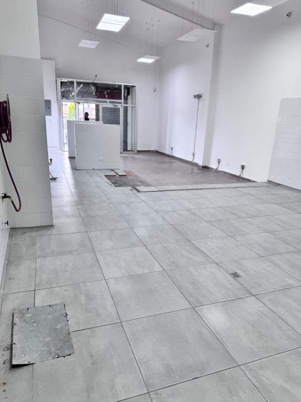 High-ceilinged commercial unit with unfinished floor and large glass storefront in Panama City