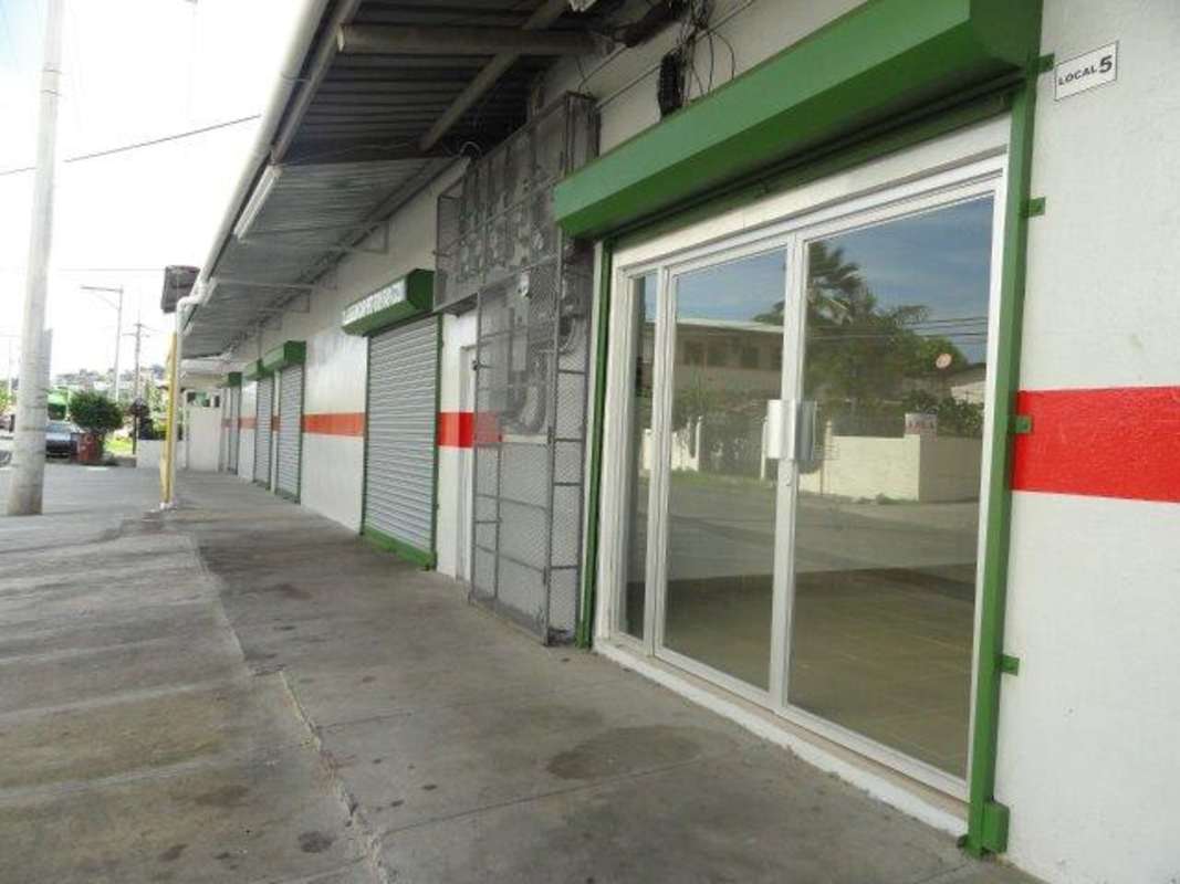 Street view of commercial units with secure metal shutters and glass doors in Panama City