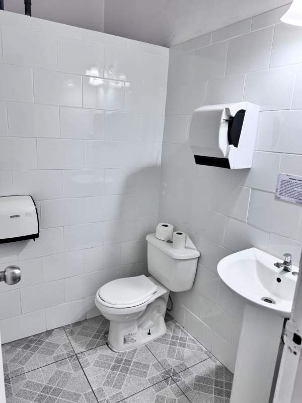 Small restroom with tiled walls, toilet, sink in commercial rental space in Rio Abajo