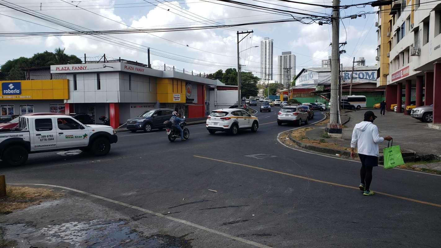 Street scene with shops, cars, motorcycles, pedestrians and signage Rio Abajo Panama City