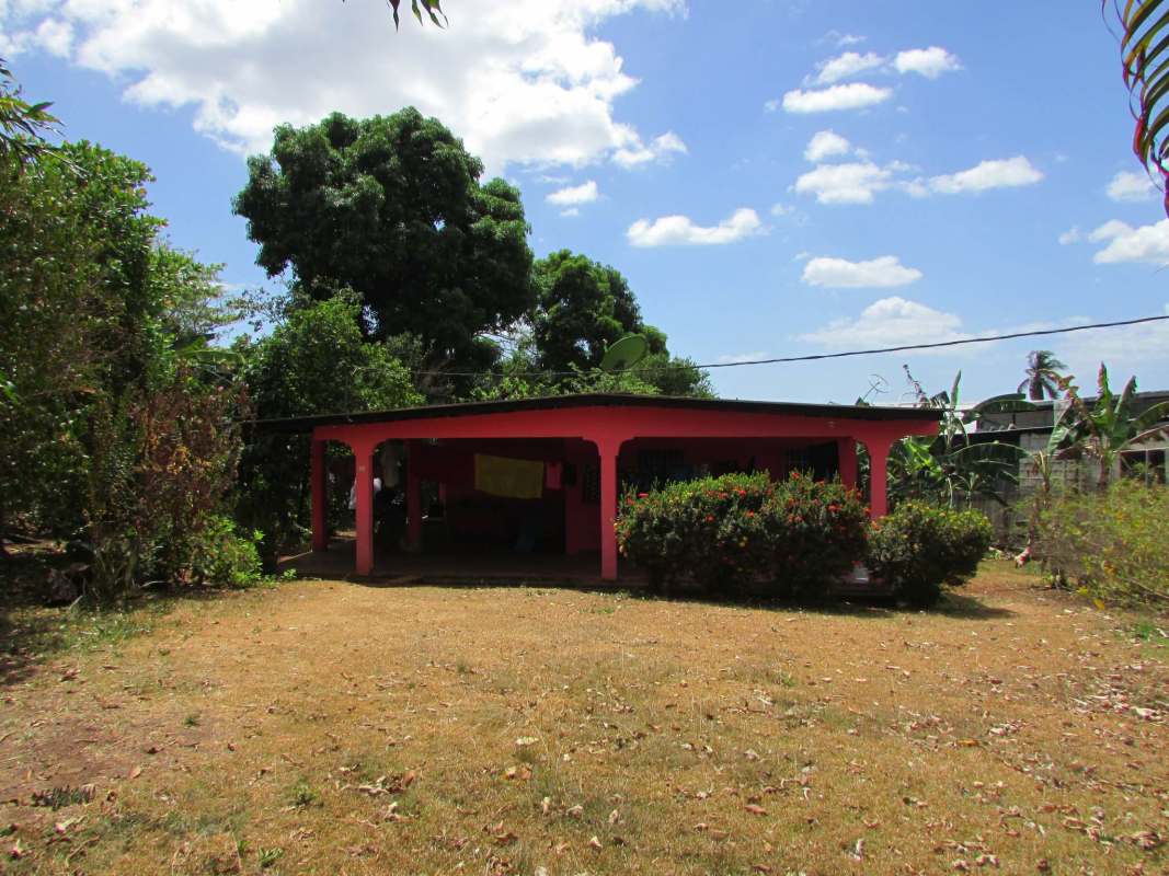 Rustic red house on green plot adjacent to Tocumen commercial land Panama