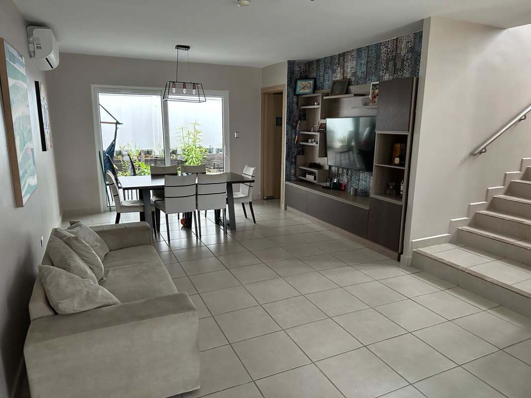 Spacious open plan living and dining room with large window and access to patio at PH Brisas del Golf Panama