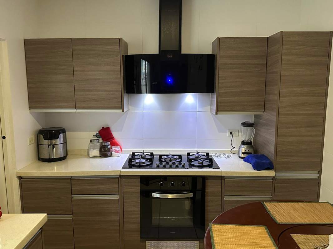 Fully equipped kitchen with wooden cabinets and gas stove in house for rent PH Brisas del Golf Panama