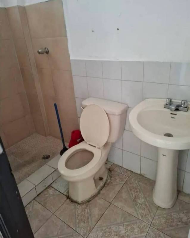 Basic bathroom pedestal sink toilet tiled walls open shower PH La Colina Panama